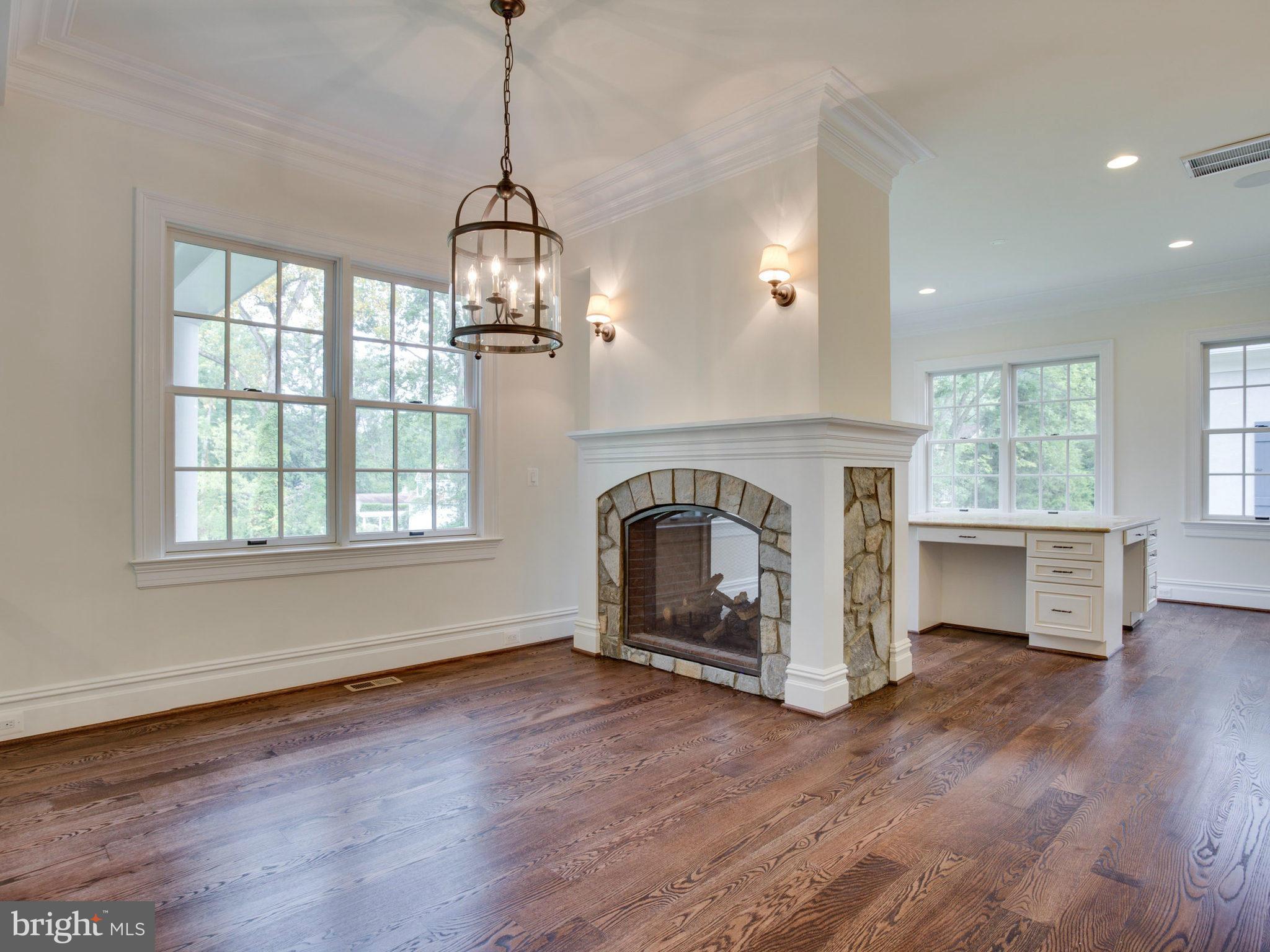 926 Douglass Drive McLean, VA 22101 - Photo 6 of 29 an empty room with wooden floor fireplace and windows