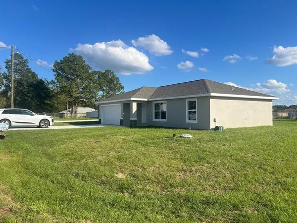 a view of a house with backyard and garden