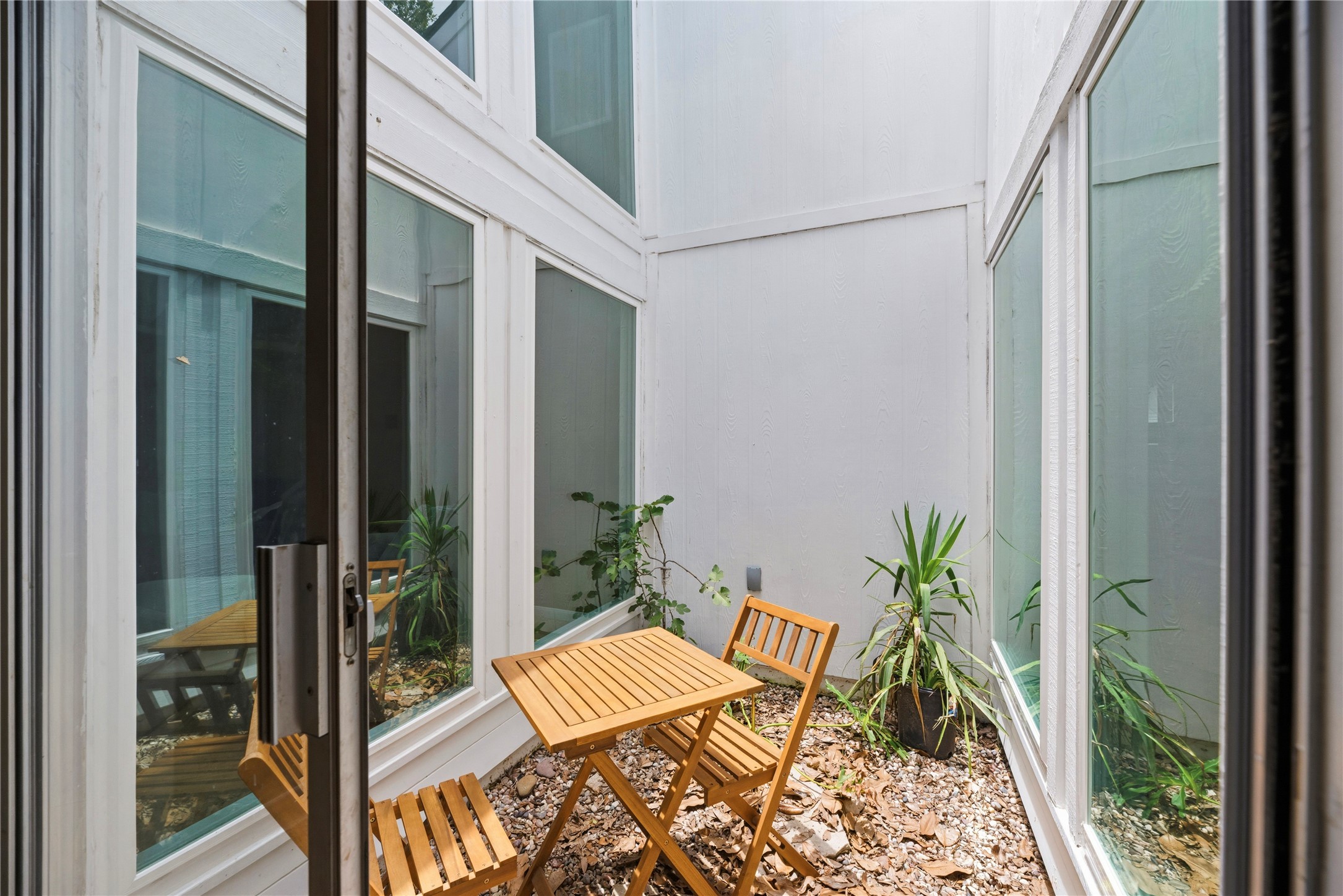 14203 Wickersham Lane Houston, TX 77077 - Photo 11 of 25 Intimate, private outdoor atrium centered in the middle of the home, featuring multiple floor-to-ceiling glass windows and sliding doors that flood the interior hallways with incredible natural light.