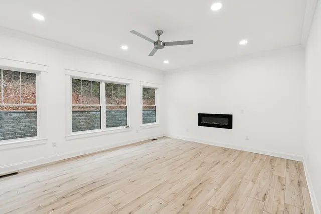 an empty room with wooden floor and windows