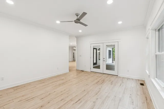 an empty room with wooden floor and windows