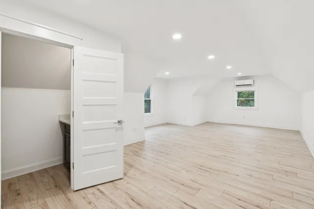 a view of empty room with wooden floor and windows
