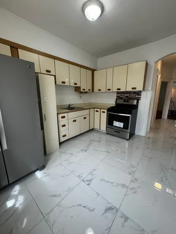 a kitchen with granite countertop a refrigerator and a stove top oven