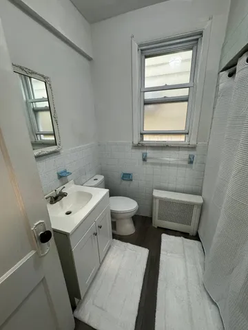 a bathroom with a sink a toilet and a window