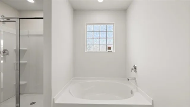 a white bath tub sitting next to a shower