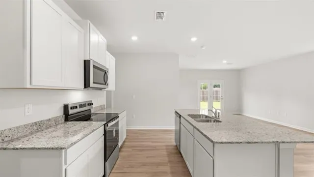 a kitchen with stainless steel appliances granite countertop a sink stove and cabinets