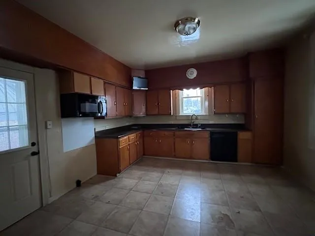 a large kitchen with a stove top oven a sink dishwasher and a refrigerator