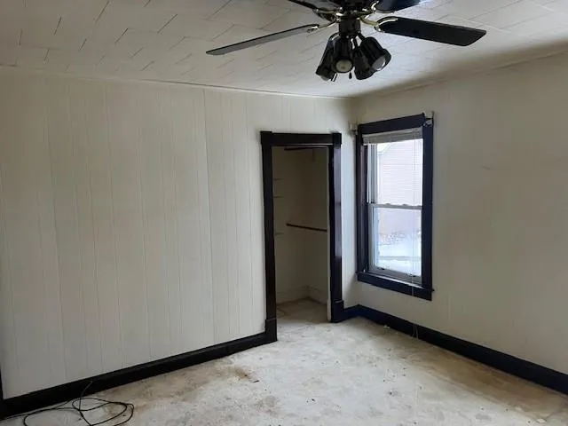 an empty room with chandelier fan