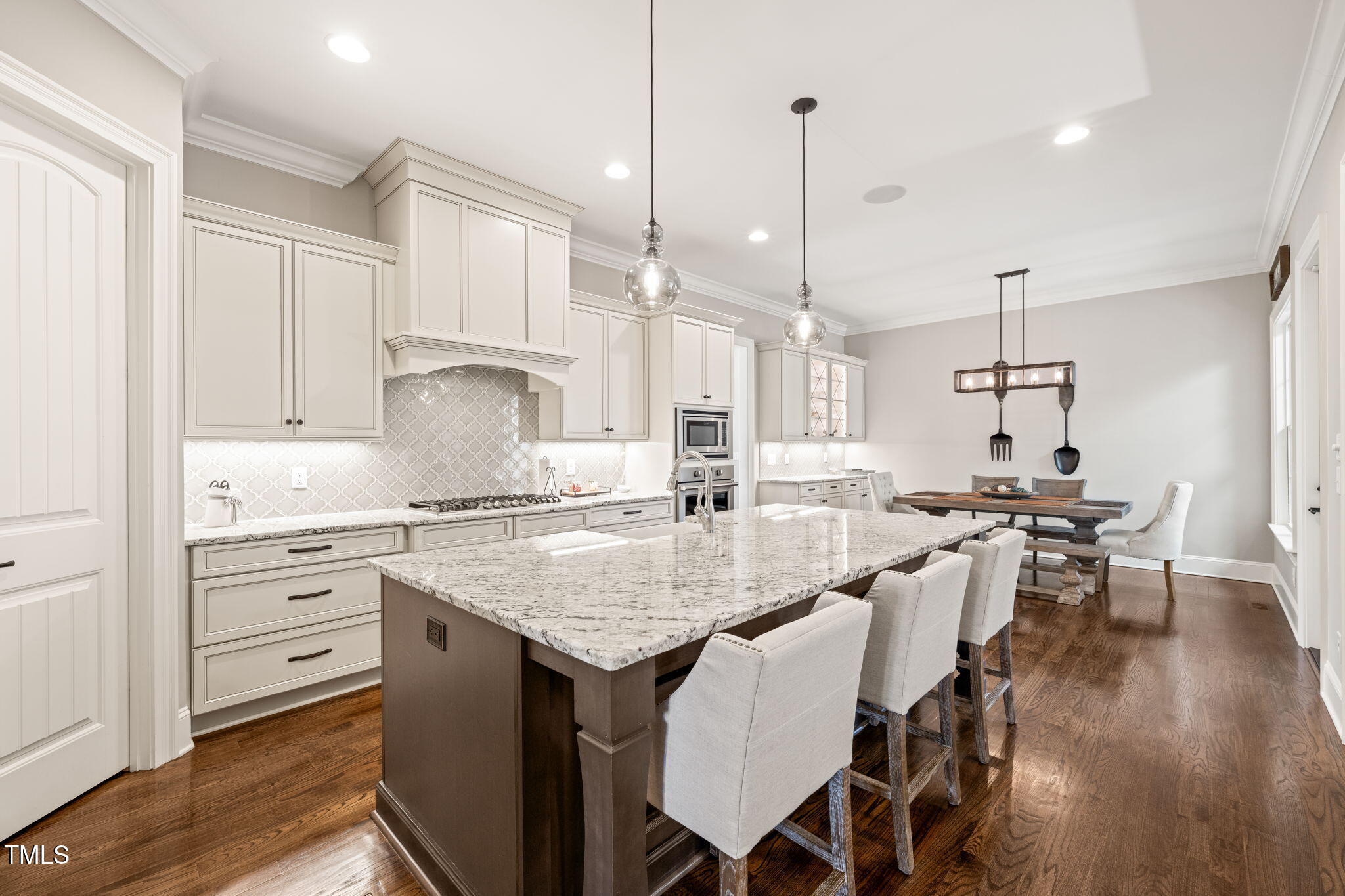 1301 Mackinaw Drive Wake Forest, NC 27587 - Photo 17 of 55 a kitchen with center island white cabinets and stainless steel appliances