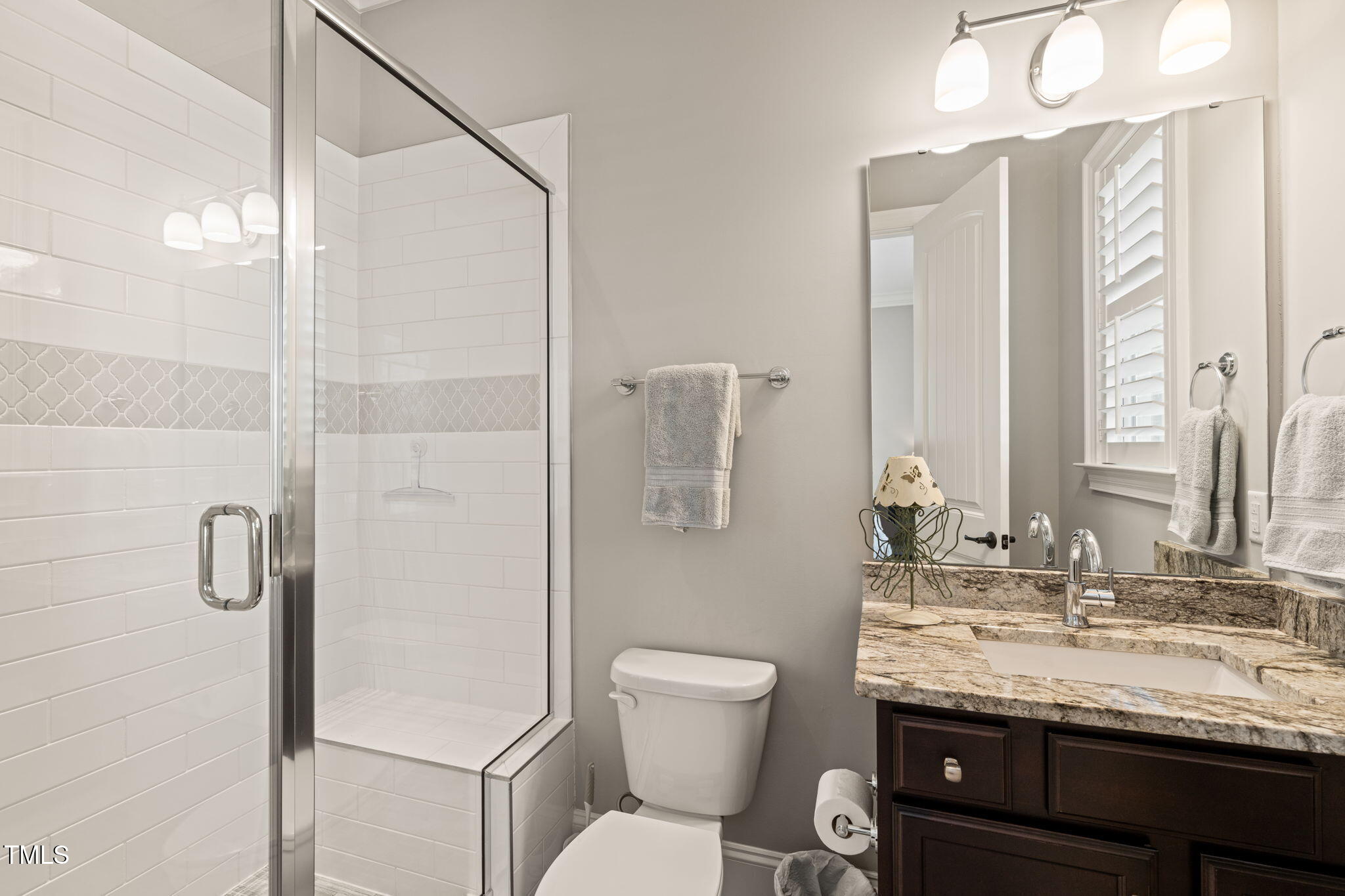 1301 Mackinaw Drive Wake Forest, NC 27587 - Photo 34 of 55 a bathroom with a granite countertop sink a toilet and shower