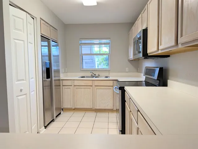 a kitchen with white cabinets and white appliances