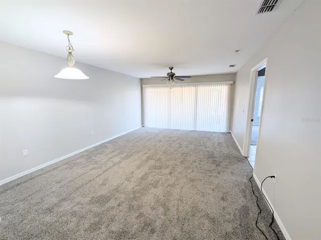 a view of a room with a ceiling fan and window