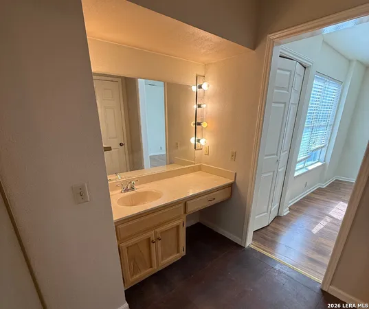 a spacious bathroom with a granite countertop sink a mirror and a vanity