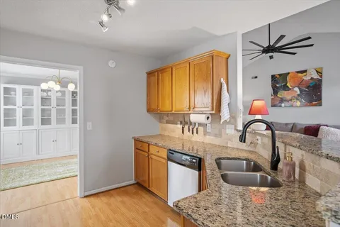 a kitchen with stainless steel appliances granite countertop a sink a stove and a wooden cabinets
