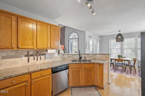 a kitchen with granite countertop a refrigerator stove and sink