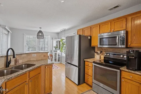 a kitchen with granite countertop cabinets stainless steel appliances and a counter space