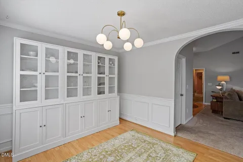 a view of an empty room with a window and chandelier