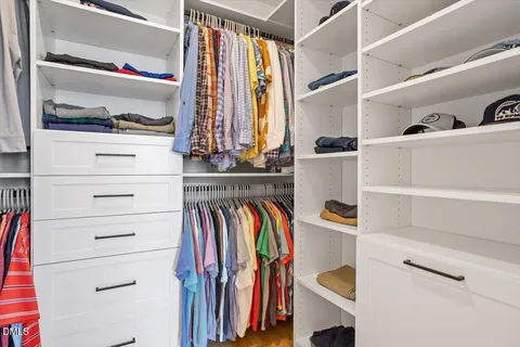a view of a bedroom with a bed and wooden floor