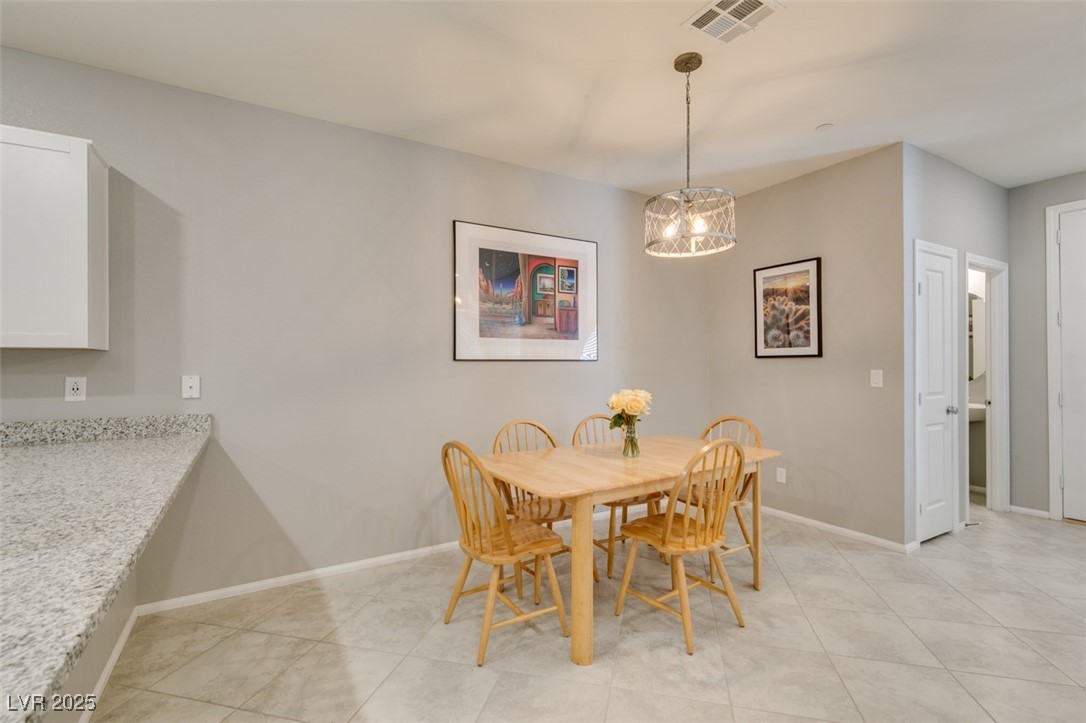 2870 Turnstone Ridge Street Henderson, NV 89044 - Photo 14 of 50 Dining space with a chandelier, baseboards, and light tile patterned floors