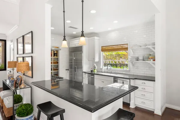 a kitchen with stainless steel appliances granite countertop a sink a stove and a wooden floors