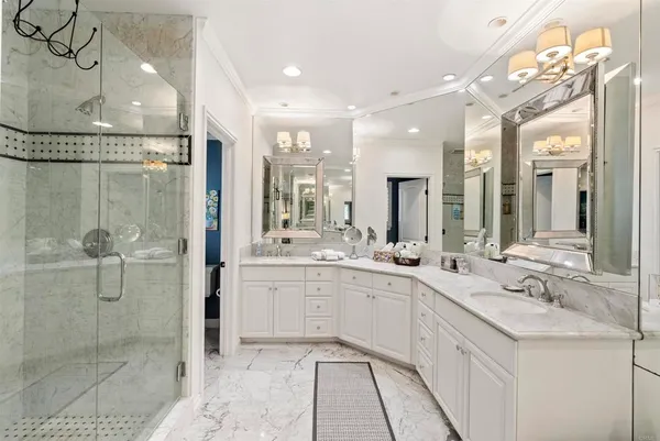 a bathroom with a double vanity sink mirror and shower