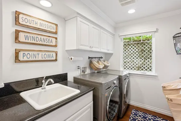 a utility room with sink dryer and washer