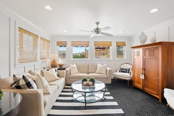 a living room with furniture a large window and a rug