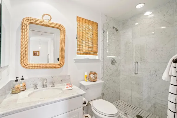 a bathroom with a sink a toilet and shower