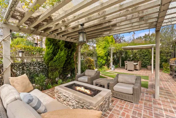 a view of a patio with couches and floor to ceiling window next to a yard