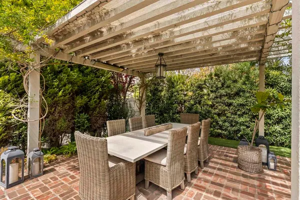 a roof deck with table and chairs and potted plants