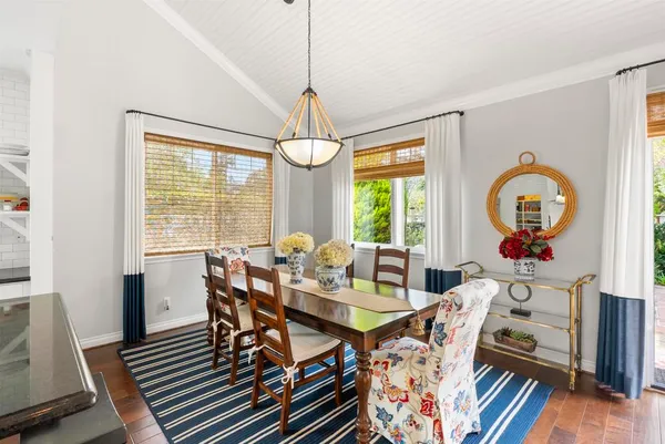 a view of a dining room with furniture a chandelier and wooden floor