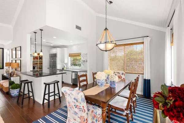 a view of a dining room and livingroom with furniture wooden floor a chandelier