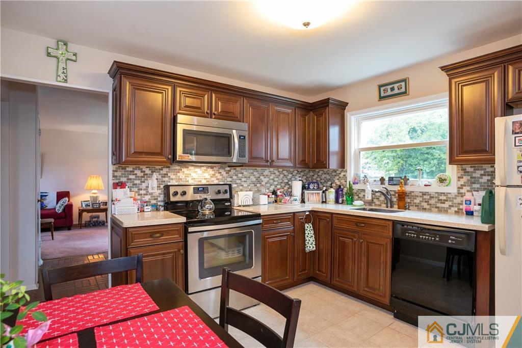 55 Gramercy Road Old Bridge, NJ 08857 - Photo 11 of 22 a kitchen with stainless steel appliances kitchen island granite countertop a sink stove and microwave