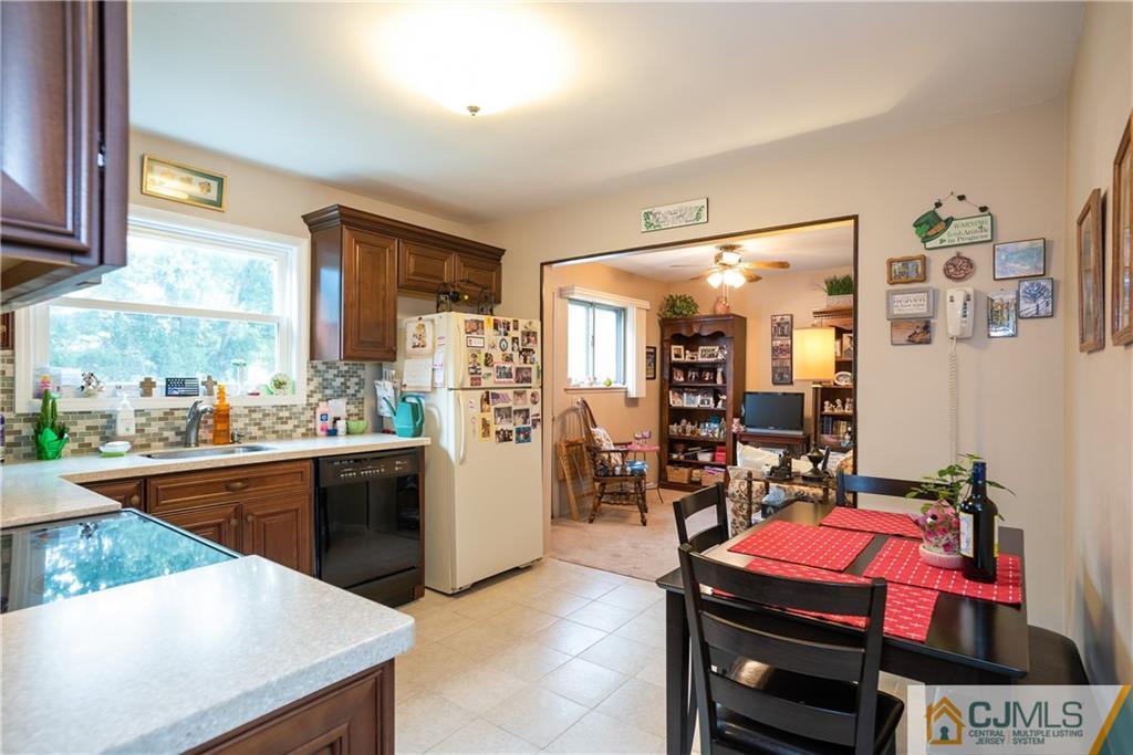 55 Gramercy Road Old Bridge, NJ 08857 - Photo 12 of 22 a kitchen with stainless steel appliances kitchen island granite countertop a table chairs in it and wooden floors
