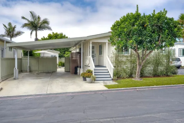 a view of a house with a yard and potted plants