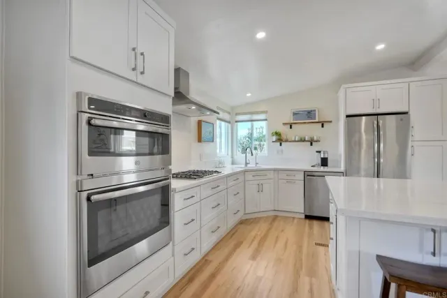 a kitchen with white cabinets and stainless steel appliances