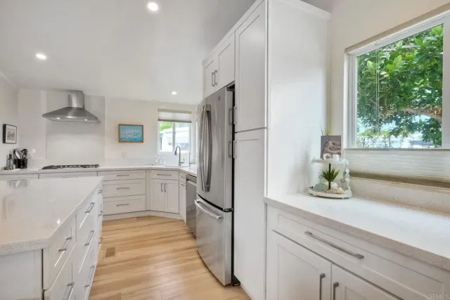 a kitchen with white cabinets and refrigerator