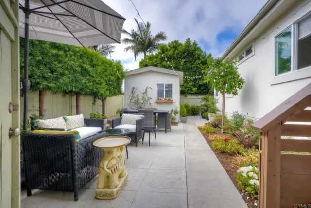 a view of a patio with table and chairs potted plants and large tree