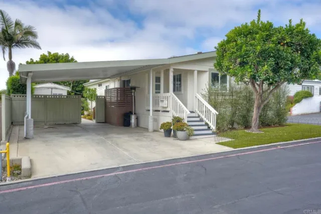 a view of a house with backyard and a tree