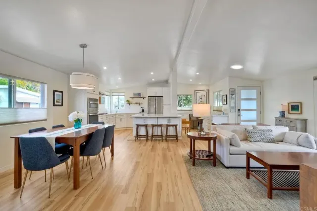 a living room with furniture a table and kitchen view