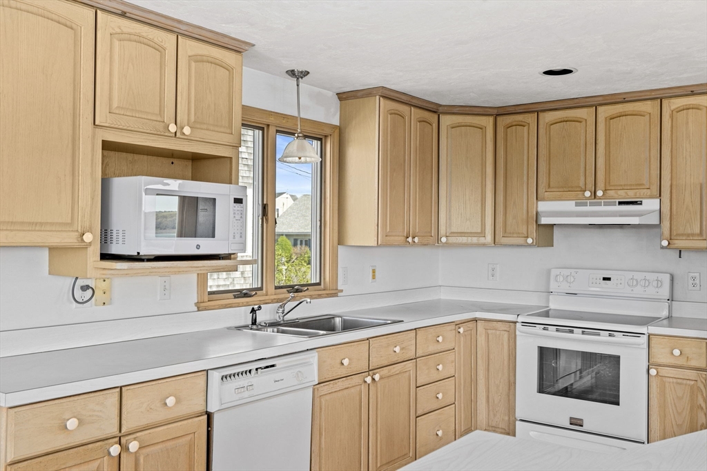 5 Silver Road Scituate, MA 02050 - Photo 7 of 30 a kitchen with stainless steel appliances granite countertop a sink a stove and cabinets