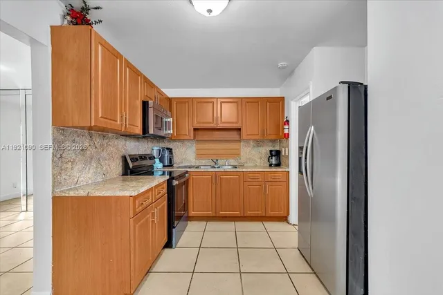 a kitchen with granite countertop a sink stove and cabinets