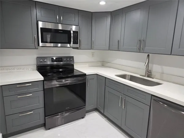 a kitchen with a sink and steel appliances