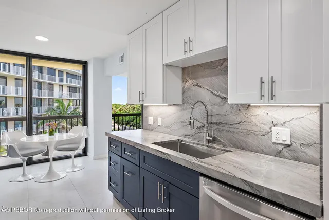 a kitchen with granite countertop a sink and white cabinets