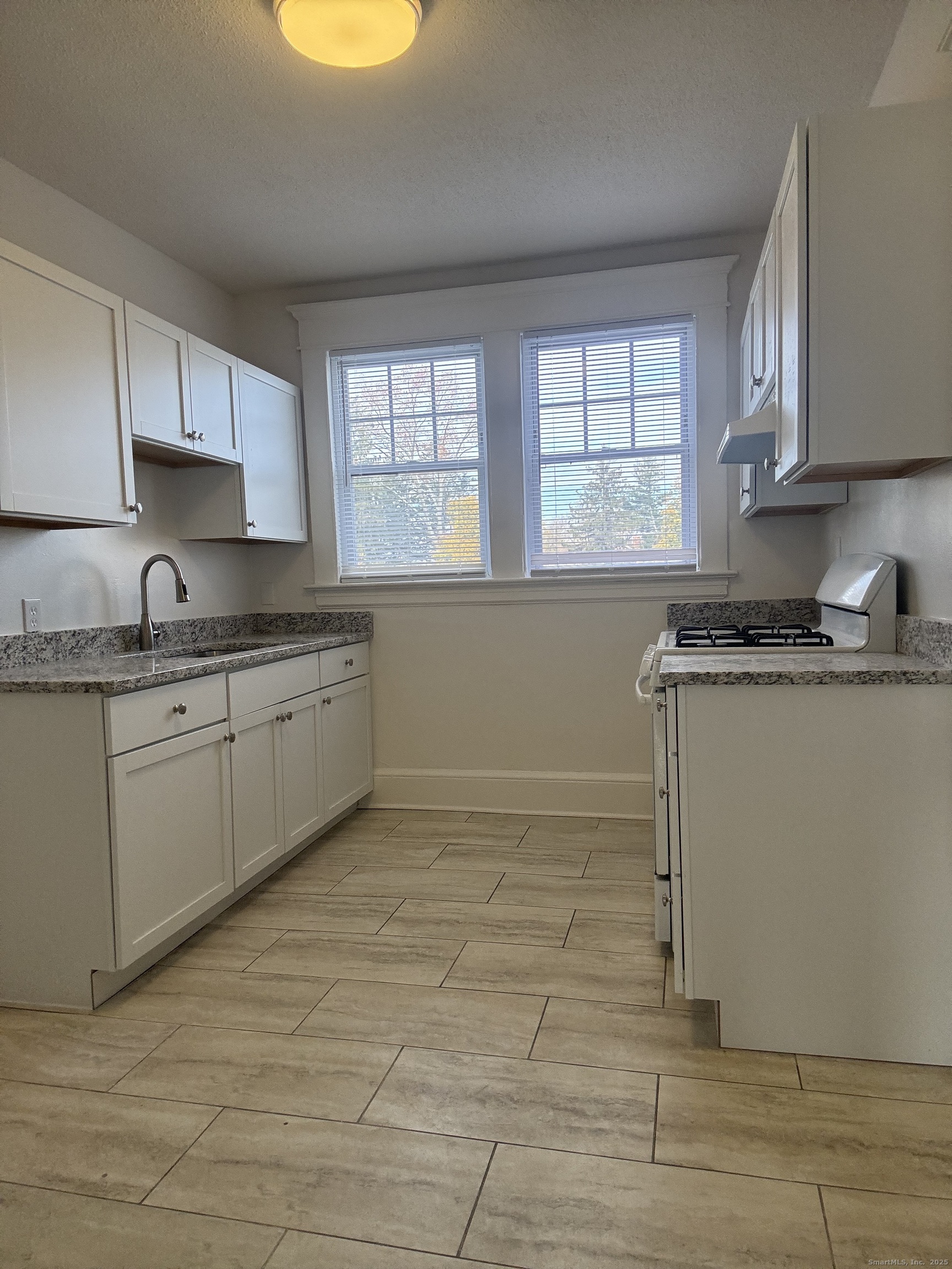 155 Elm Street, Unit 6 West Haven, CT 06516 - Photo 2 of 8 a kitchen with a sink window and cabinets