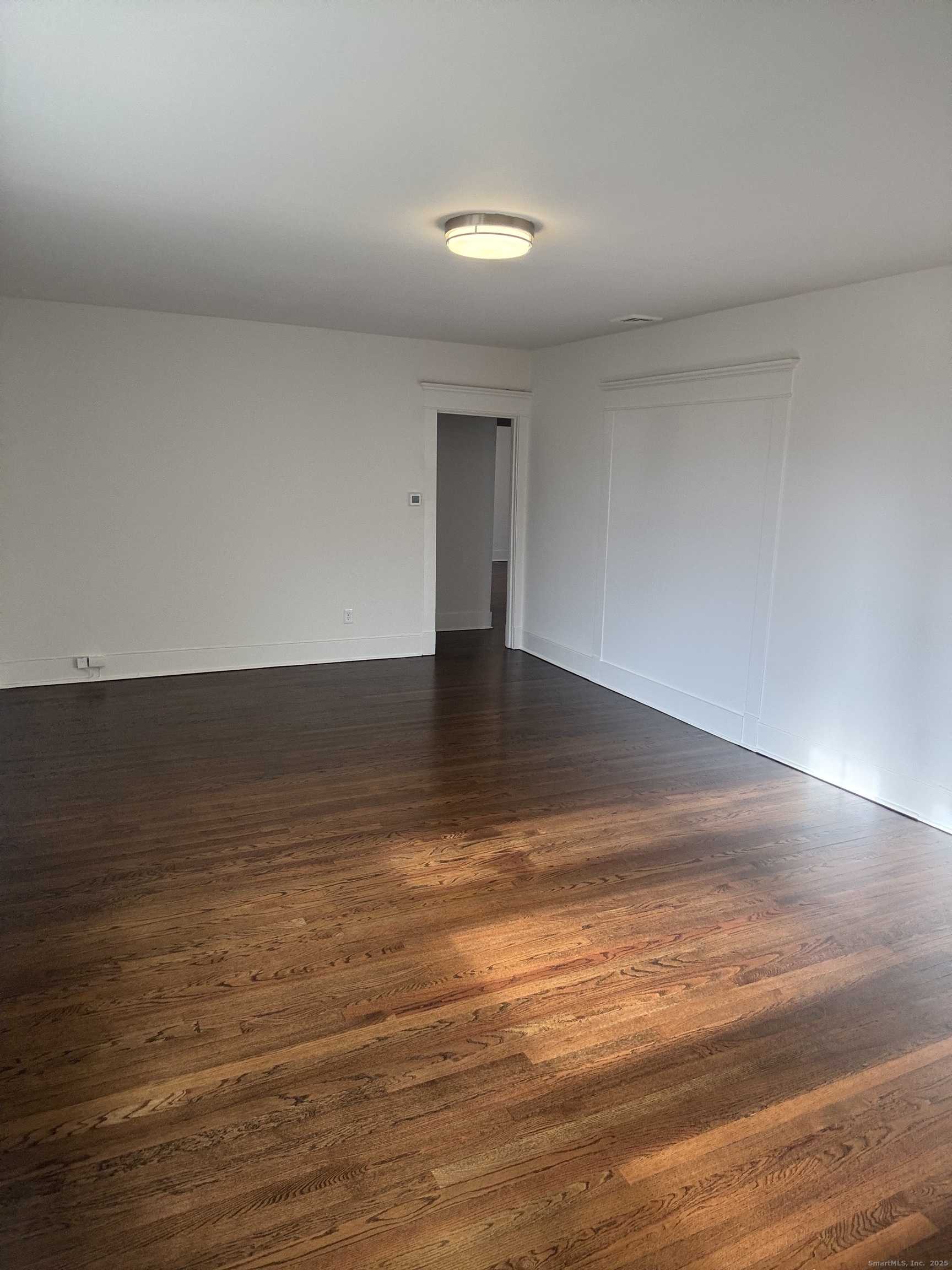 155 Elm Street, Unit 6 West Haven, CT 06516 - Photo 4 of 8 a view of an empty room with wooden floor and a window