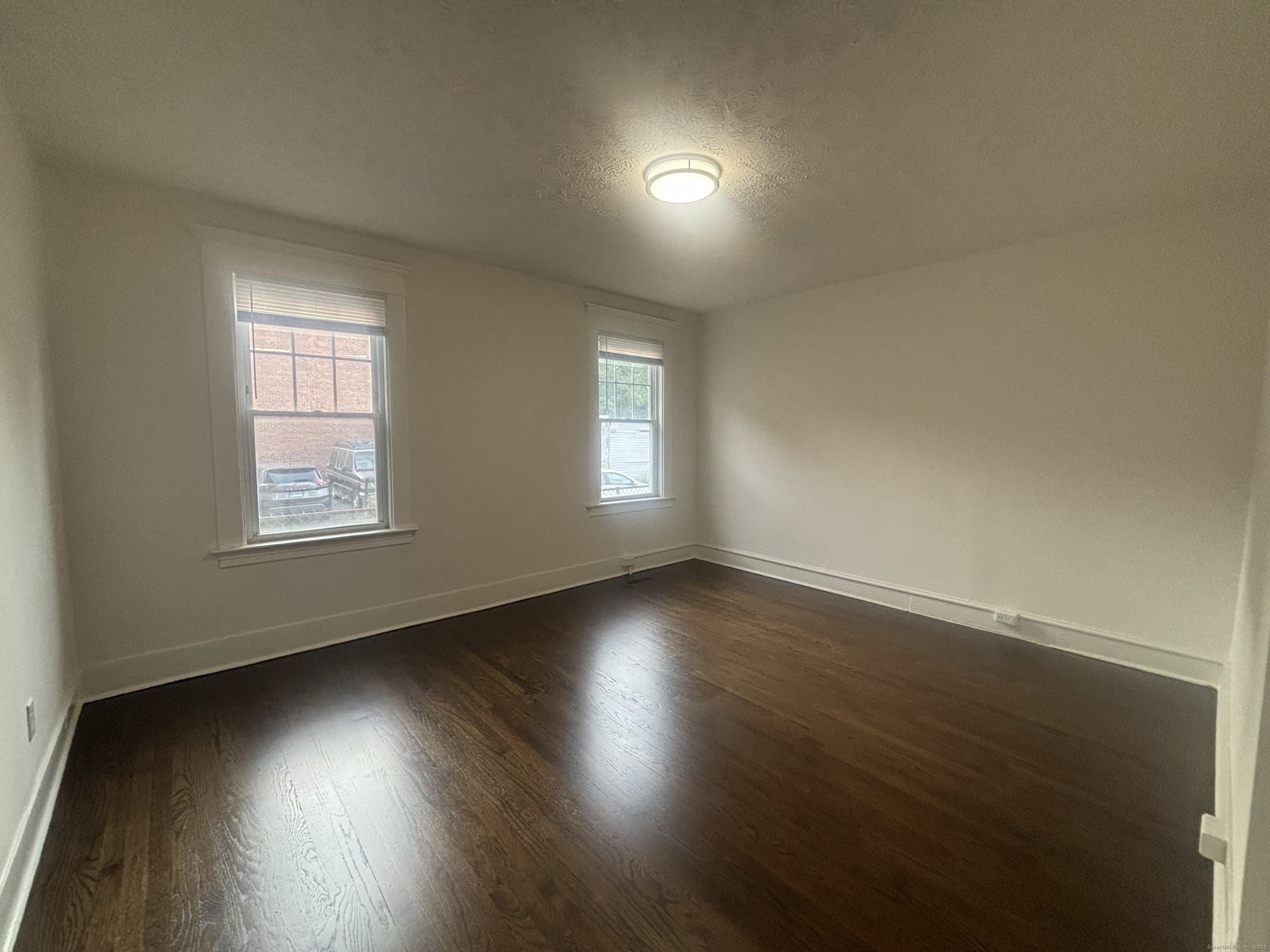 155 Elm Street, Unit 6 West Haven, CT 06516 - Photo 6 of 8 an empty room with wooden floor and windows