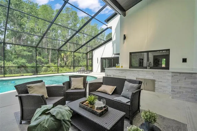 a living room with patio furniture and a garden