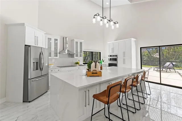a kitchen with stainless steel appliances a dining table and chairs