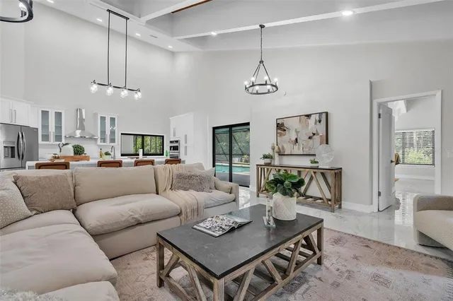 a living room with furniture a dining table and a chandelier